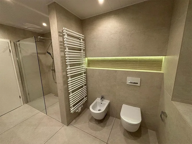 Bad mit bodengleicher Glasdusche, Handtuchheizkörper, beleuchteter Nische, WC und Bidet